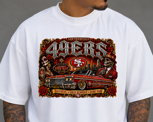 A white crewneck t-shirt featuring a large, detailed graphic print of the San Francisco 49ers. The graphic includes the team name in stylized lettering, a red and gold SF logo, a vintage car, and a skeleton character, all set against a gray background.